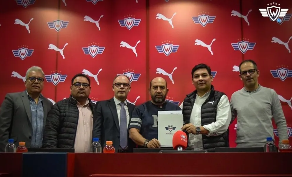 El presidente Mustafá sostiene el contrato durante la firma del convenio con Puma. Foto: Club Wilstermann.