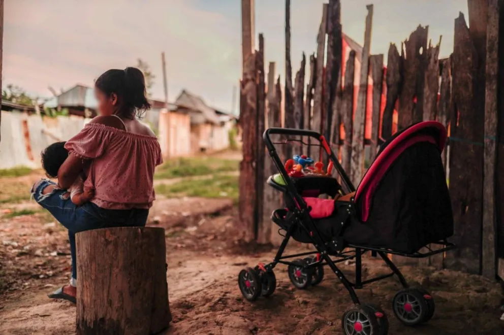 Fotografía de archivo de una madre adolescente sentada con su hijo en Iquitos (Perú). EFE/ Aldair Mejía