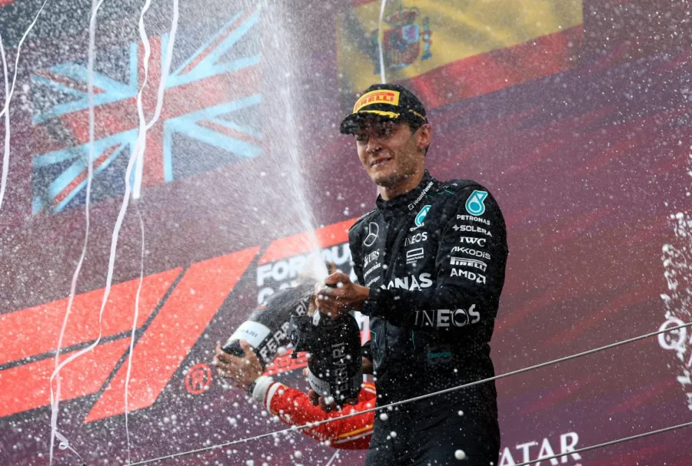 Russell celebra en el podio de los mejores con el champagne. Foto EFE