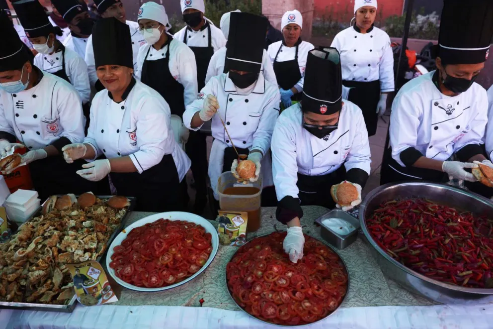 Cocineros preparan salsas durante la presentación del Sándwich de chola más grande del mundo, este martes en La Paz. Foto: EFE