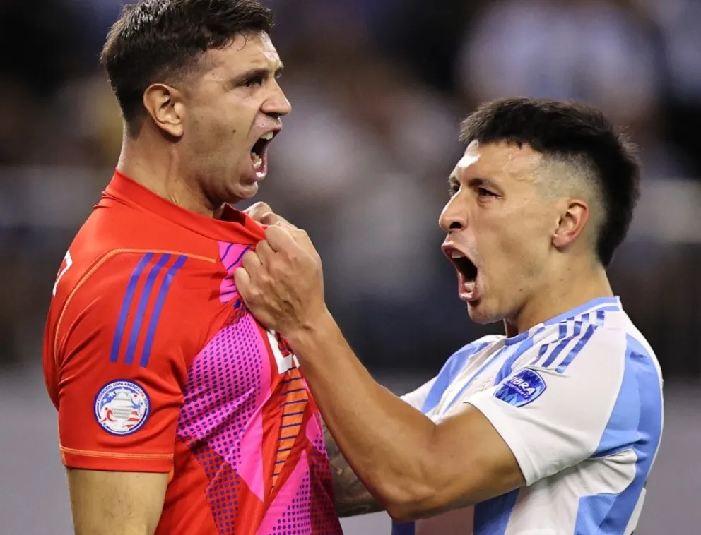 El "Dibu" Martínez celebra su gran atajada con Lizandro Martínez. Foto EFE