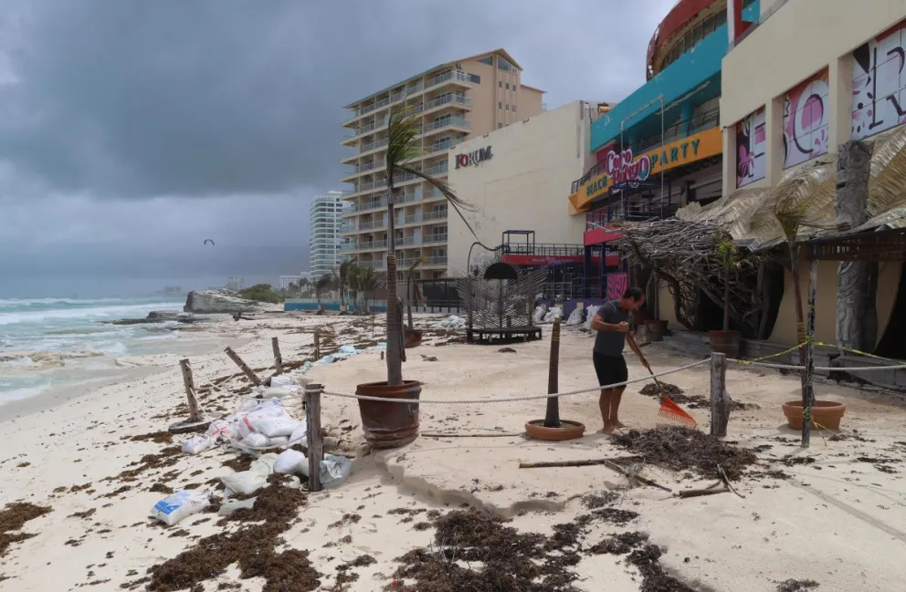 Personal de servicio limpiando sus negocios después del paso del huracán en las principales playas en el balneario de Cancún en Quintana Roo (México). Foto: EFE