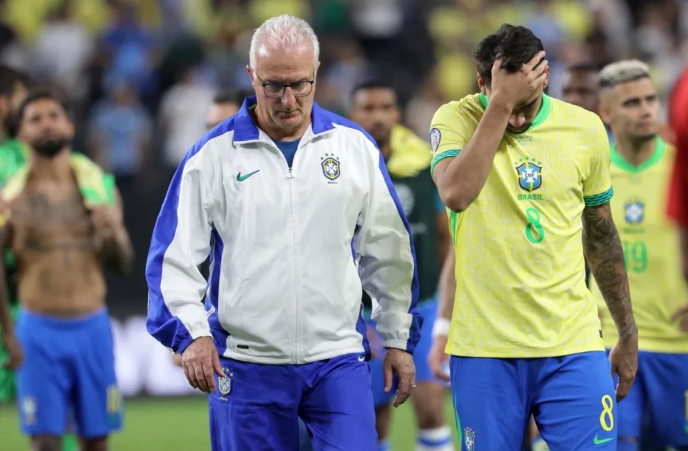 Dorival Junior y Lucas Paquetá se retiran con la cabeza gacha tras la derrota ante Uruguay. Foto: EFE