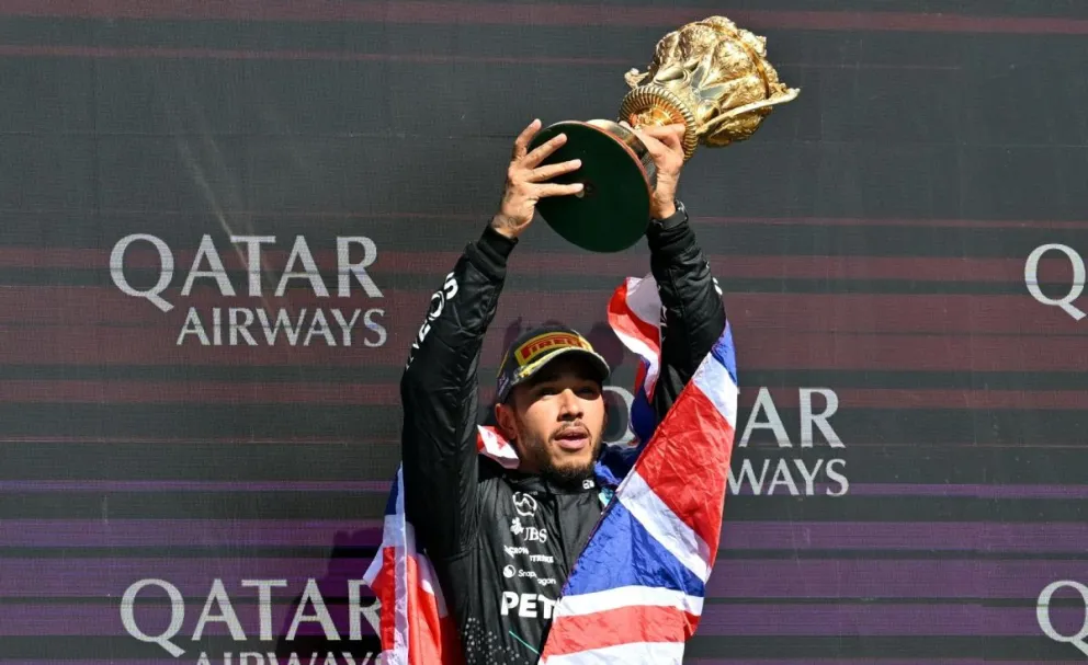 Lewis Hamilton, con el trofeo en sus manos, festeja su victoria en Gran Bretaña. Foto: EFE