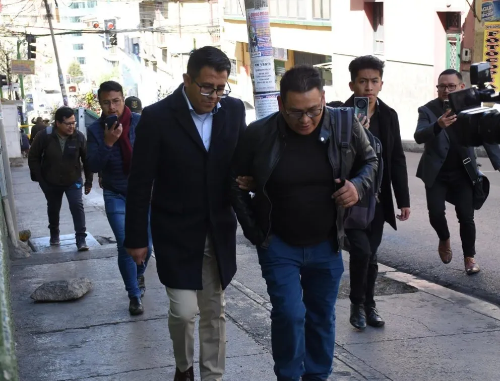 El abogado Abel Loma (Izq), lleva del brazo al funcionario del Legislativo que intentaba extorsionar 74.400 bolivianos. Foto: APG