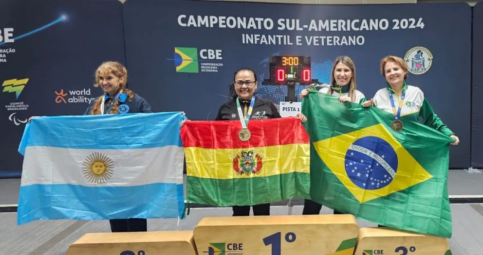 Ribera agarra la bandera nacional con su medalla. Foto: Federación Boliviana de Esgrima.