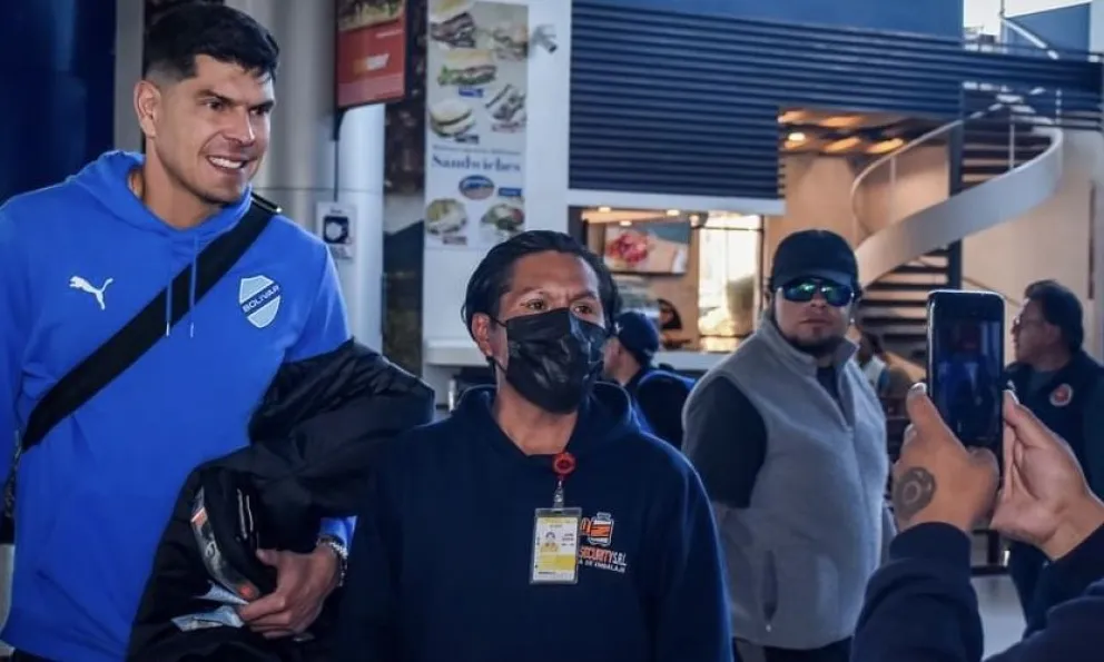 El arquero Carlos Lampe atiende el pedido de un hincha para tomarse una foto antes del viaje de Bolívar a Santa Cruz. Foto: Bolívar.