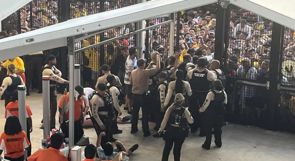 Varios policías cierran los accesos al escenario. Varios aficionados aparecen en el piso. Foto: EFE