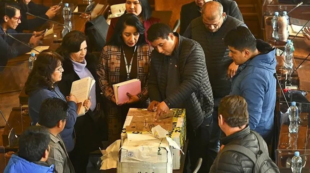 Integrantes de la Comisión de la Asamblea Legislativa abren los sobres de las pruebas para judiciales. Foto: APG
