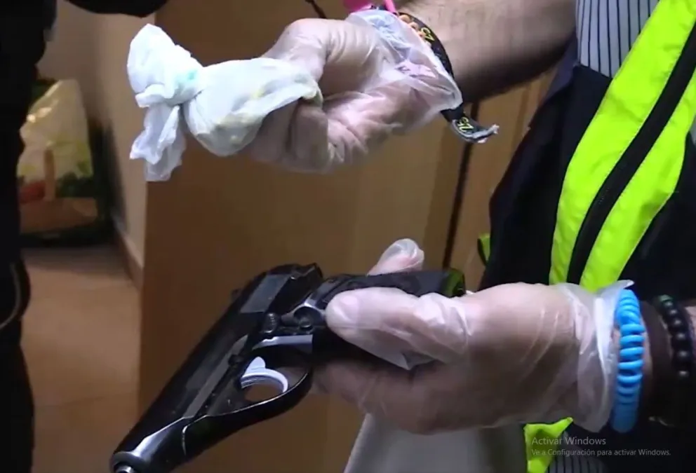 Un policía con armas y droga tras el operativo. Foto: Captura de video