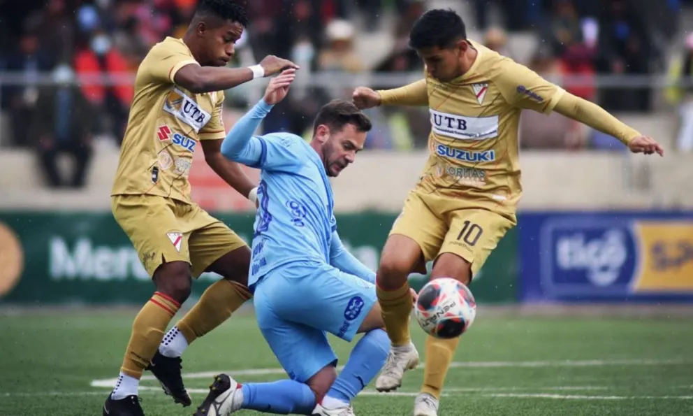 Fernando Saucedo intenta eludir la marca de dos jugadores millonarios en un partido de 2023. Foto: AR