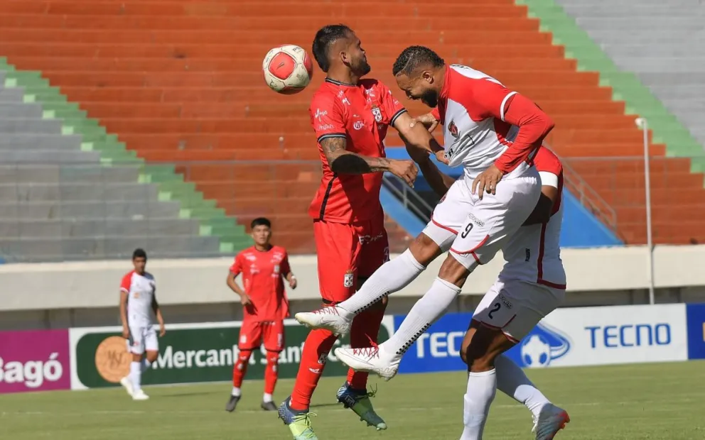 Tommy Tobar (der.), delantero de FC Universitario, conecta de cabeza el balón en el lance con Real Santa Cruz. Foto: APG