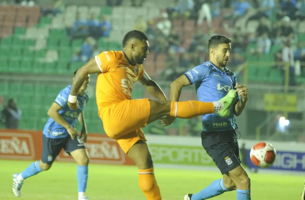 El atacante brasileño Matheus Alves remata ante la presencia de Lacerda. Foto APG