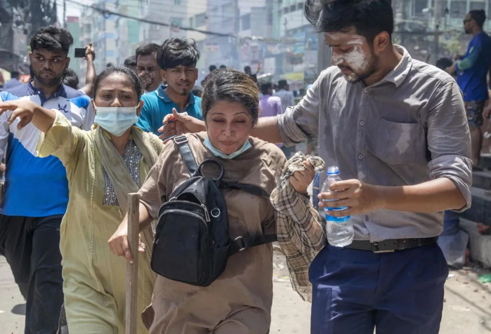 Una persona herida recibe asistencia mientras los manifestantes se enfrentan a la policía durante las protestas de estudiantes en Daca, Bangladés, el 18 de julio de 2024. Foto: EFE