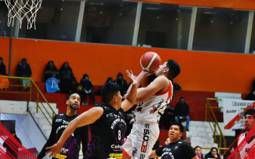Un jugador de Nacional (de blanco) intenta encestar la pelota en su duelo con Kinwa. Foto: Nacional Potosí.