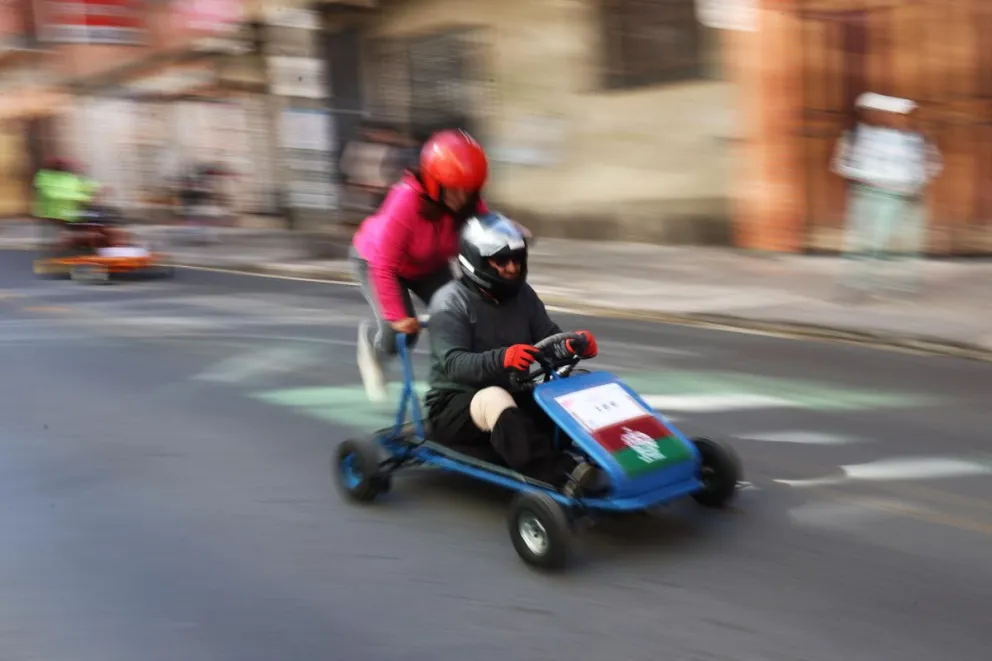 Concursantes participan en la tradicional carrera de coches sin motor. Foto: EFE / Luis Gandarillas
