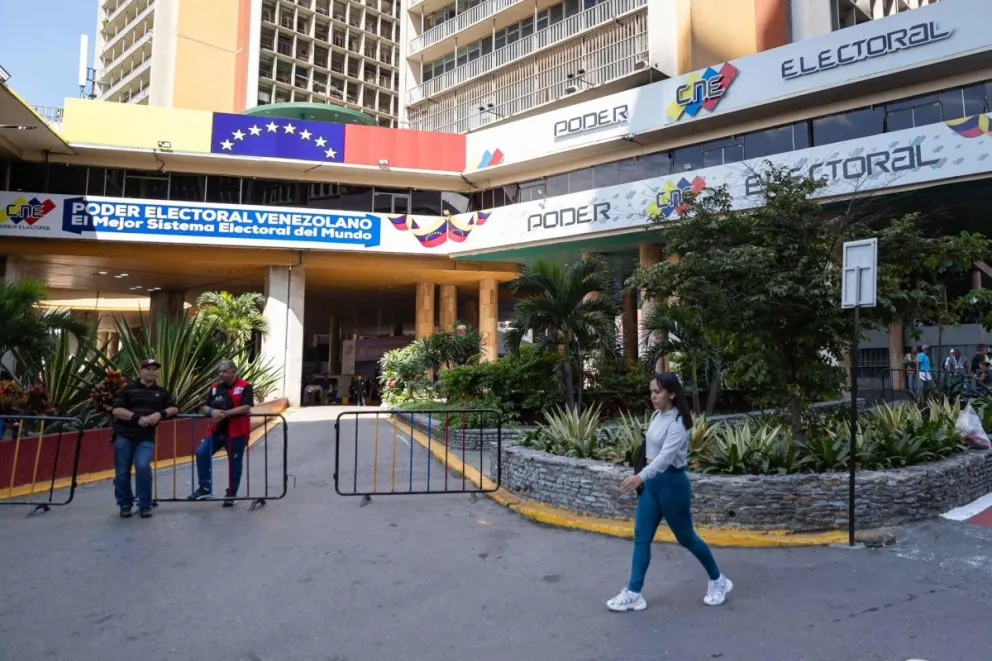 Una mujer pasa por el Consejo Nacional Electoral (CNE) en Caracas. Foto: EFE