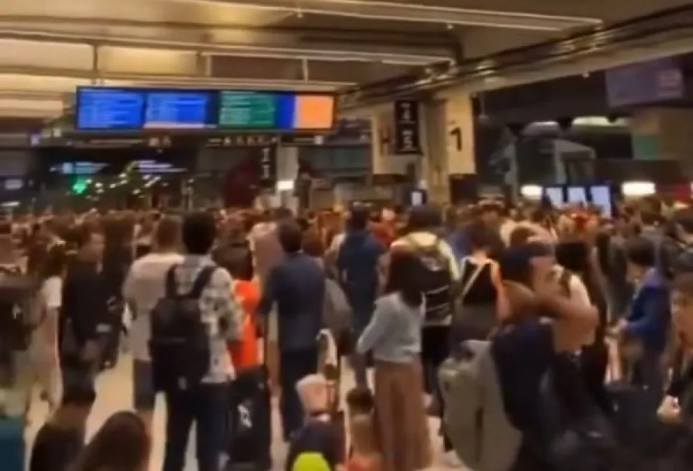 Pasajeros ven las pantallas de retrasos en una estación de París. Foto: Captura de video