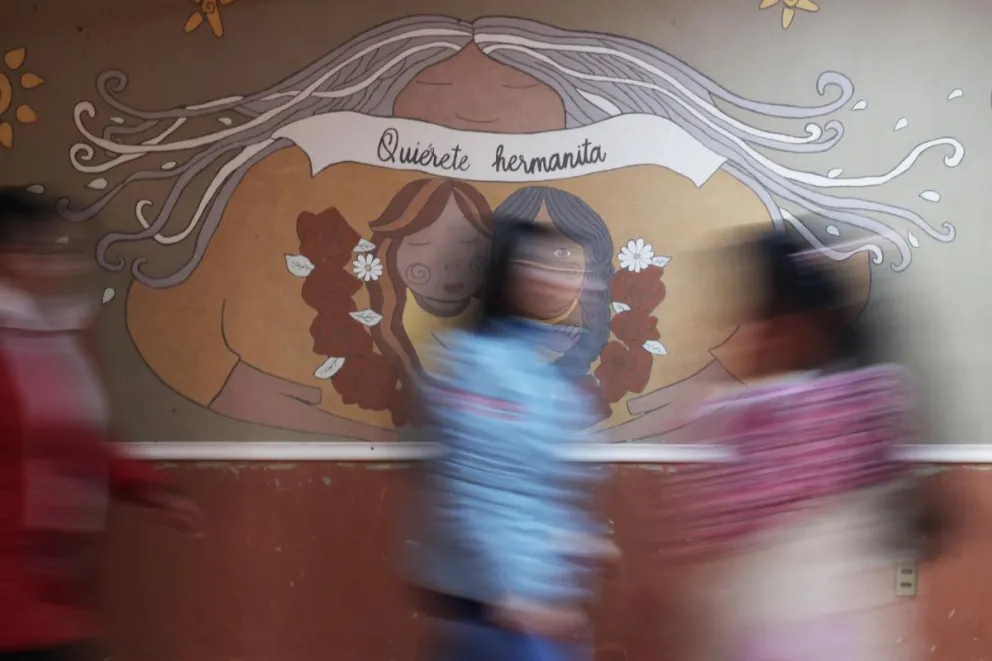 Fotografía del 22 de julio de 2024 de mujeres frente a un mural pasando en la fundación Munasim Kullakita, en La Paz. Foto: EFE / Luis Gandarillas