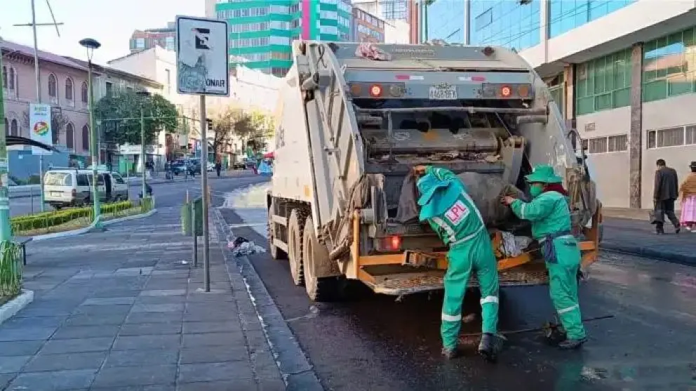 Dos trabajadores de La Paz Limpia recogen residuos sólidos en una calle céntrica de la ciudad. Foto: AMUN