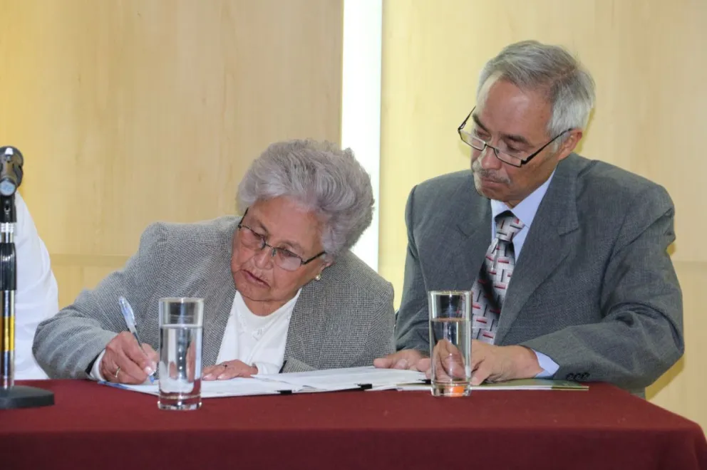 Laura Nieto Aguirre, viuda de Mario Montaño Aragón, firma el acuerdo.  FOTO: FCBCB
