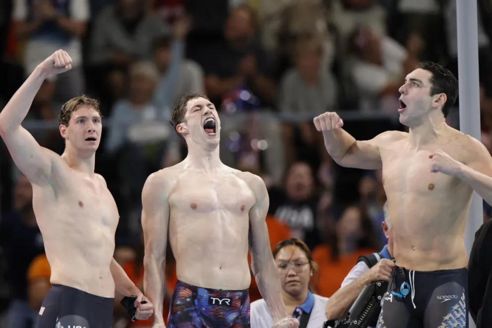El equipo estadounidense, compuesto por Jack Alexy (d), Chris Guiliano (i) y Hunter Armstrong (c), celebra el oro en la final de 4x100m Estilo Libre Masculino de los Juegos, este sábado, en París, Francia. Foto EFE