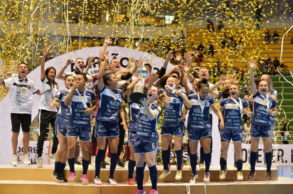 Las jugadoras brasileñas con el trofeo que de campeón que les entregó el presidente de la FBF. Foto APG