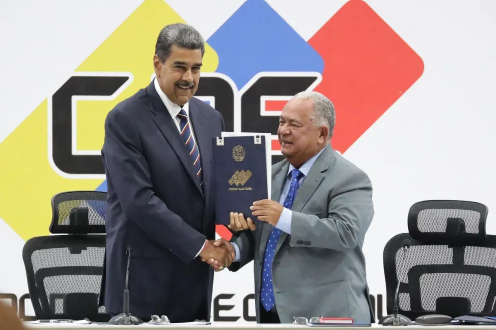 El presidente de Venezuela, Nicolás Maduro, y el presidente de Consejo Nacional Electoral (CNE), Elvis Amoroso, sostienen el acta de juramentación del presidente electo este lunes. Foto: EFE/ Ronald Peña R.