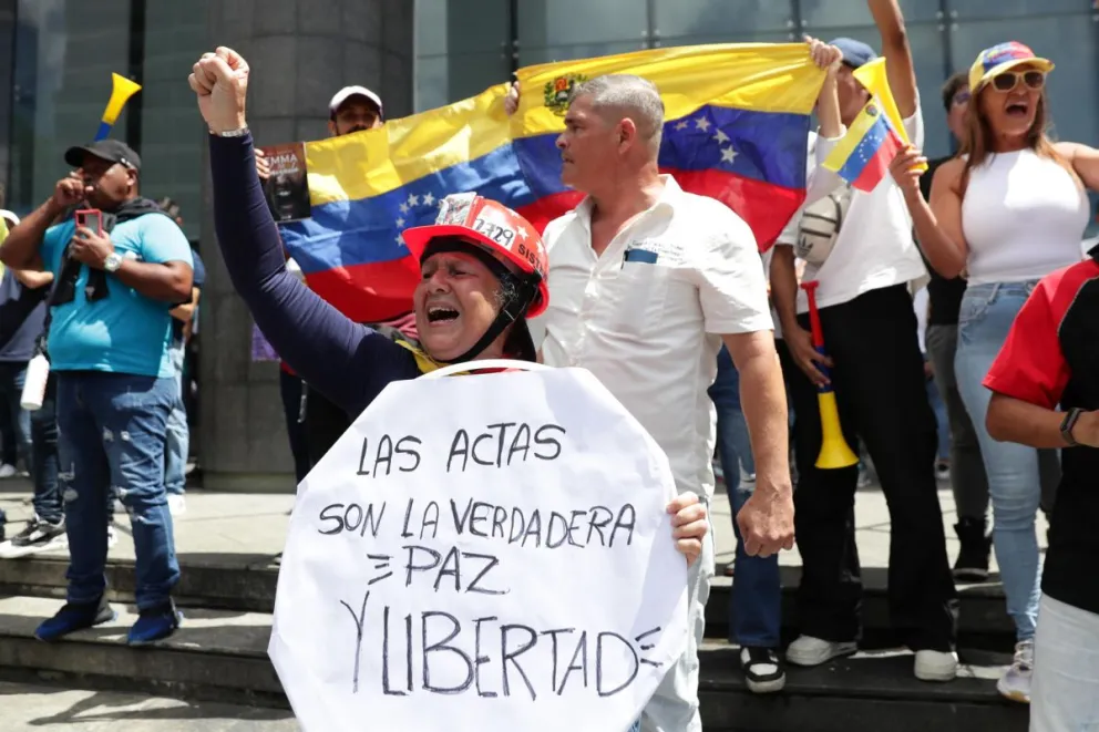 Una mujer sostiene un cartel este martes, durante una protesta contra los resultados dados por el CNE, en Caracas (Venezuela). Foto: EFE