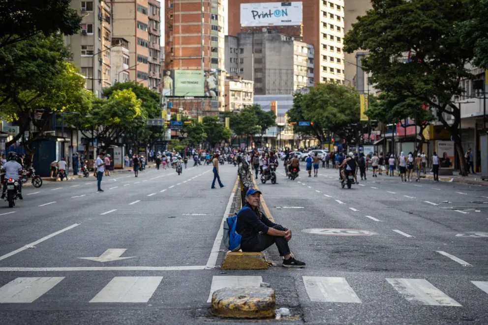 Un hombre que observa a manifestantes durante enfrentamientos entre opositores y miembros de la Guardia Nacional Bolivariana (GNB), por los resultados de las elecciones presidenciales, en Caracas. Foto: EFE 