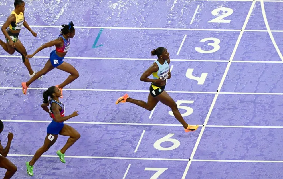 La santalucense Julien Alfred cruza la meta de los 100 metros por delante de las dos atletas estadounidenses. Foto: EFE