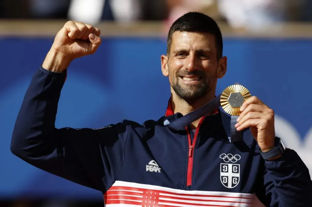 El serbio Novak Djokovic muestra su medalla en el podio. Foto: EFE