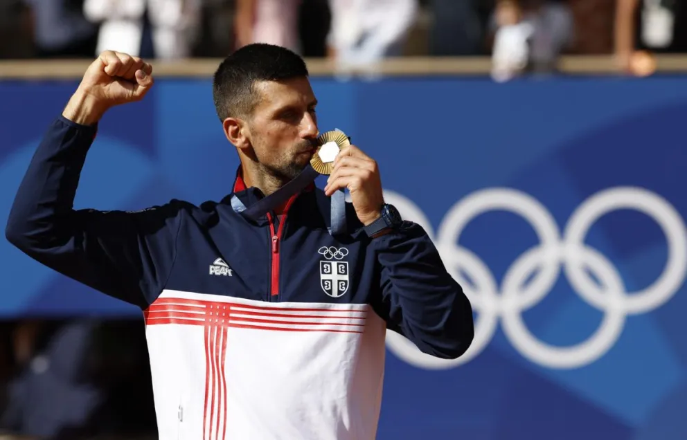 Novak Djokovic besa la medalla de oro que ganó tras superar a Carlos Alcaraz en la final del tenis. Foto: EFE