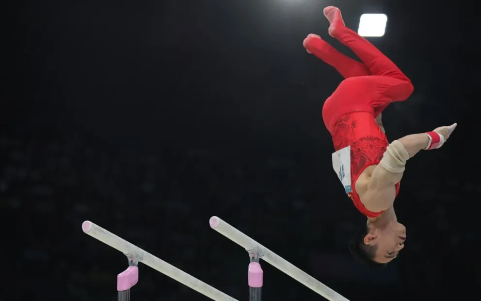 Jingyuan Zou, de China, en los momentos que finaliza su participación en las barras paralelas. Foto: EFE