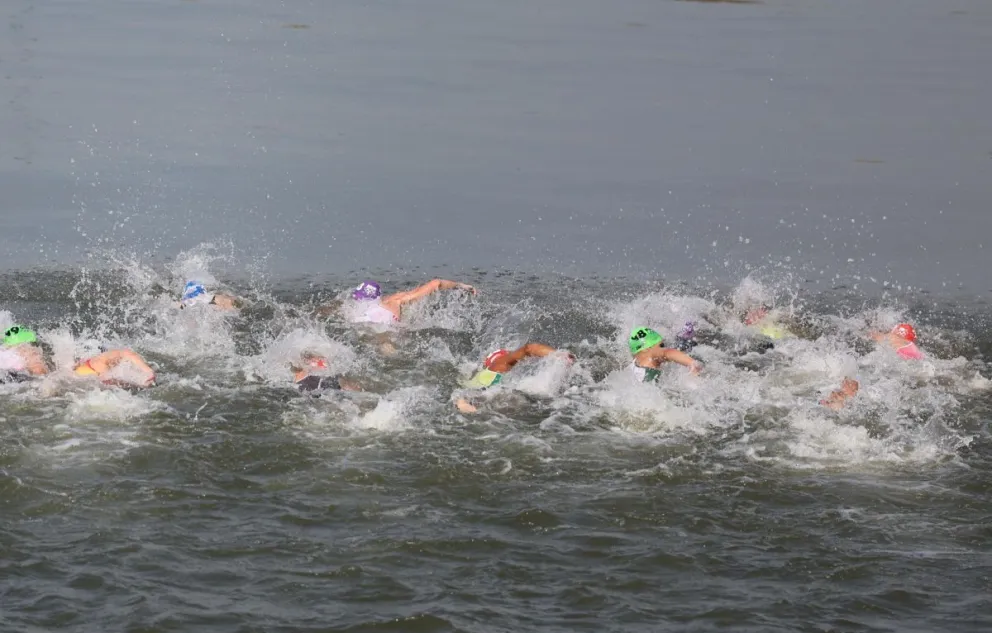 Un grupo de triatletas nada el primer segmento del triatlón masculino, que se disputó hace unos días en el Sena. Foto: EFE