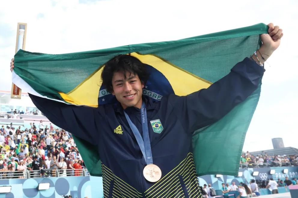 El brasileño Augusto Akio con su medalla de bronce y su bandera. Foto: EFE.