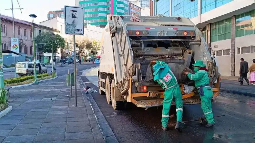 Dos trabajadores de La Paz Limpia recogen residuos sólidos en el centro de La Paz. Foto: AMUN