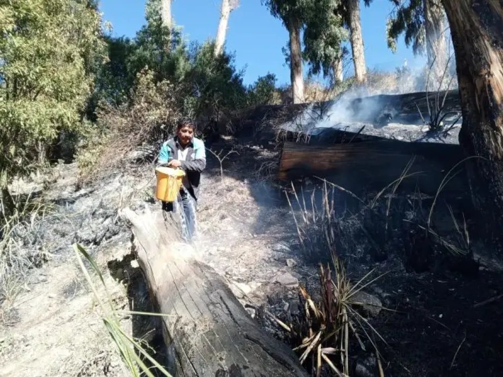 Un funcionario municipal ayuda a apagar el incendio en Kenani Pata. Foto: GAMLP
