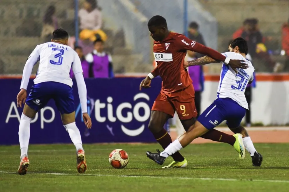El atacante Carlos Lucumí intenta burlar la marca de dos jugadores orureños. Foto: CAR
