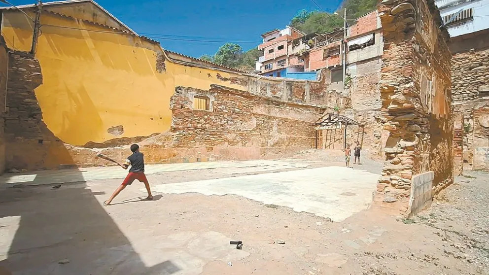 Niños juegan béisbol en las ruinas de una casa colonial, en el estado de la Guaira, Caracas. Foto: Carlos Quisbert