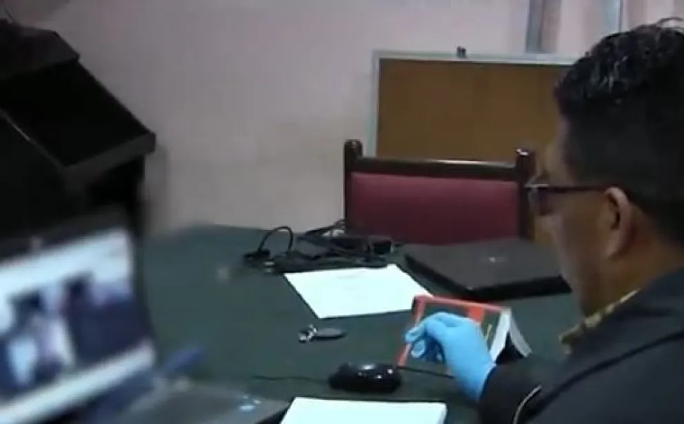 Un abogado revisa las imágenes de la audiencia. Foto: Captura de video