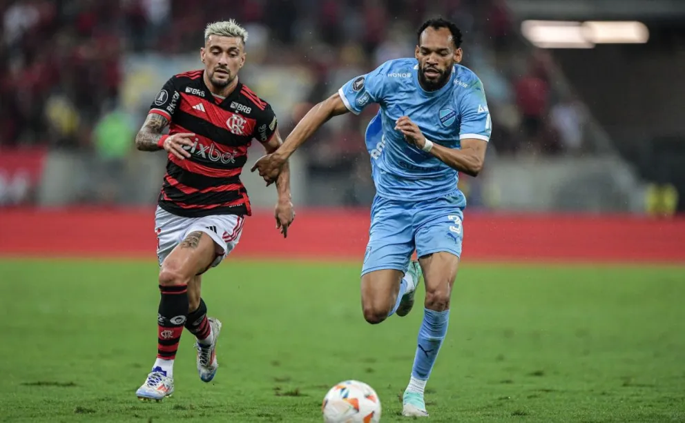 De Jesús (izq.), de Bolívar, corre por la pelota con De Arrascaeta. Foto: Conmebol.