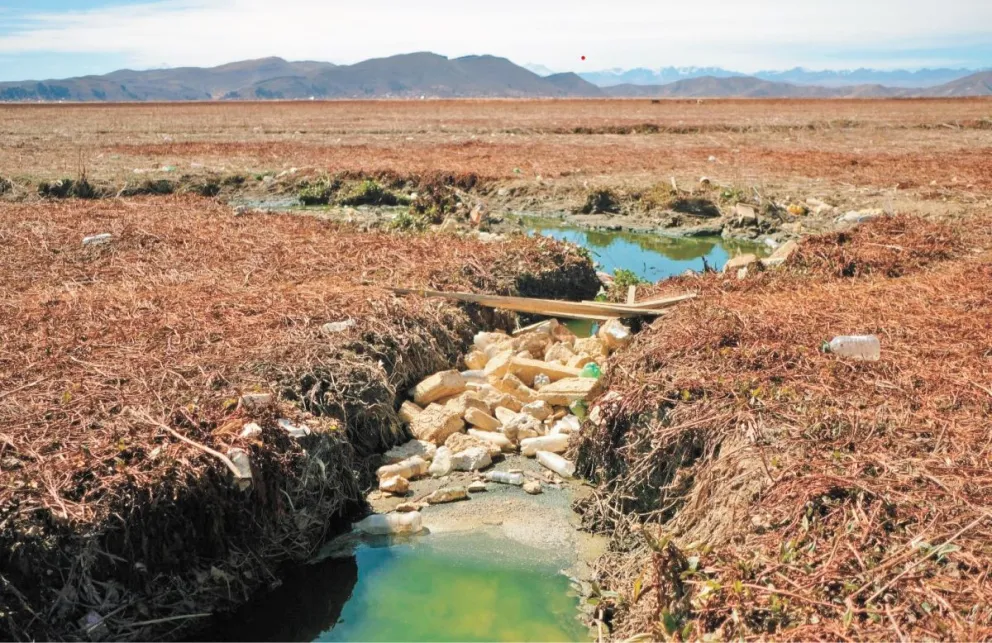 Basura estancada en un puente improvisado en la desembocadura del río Katari. 