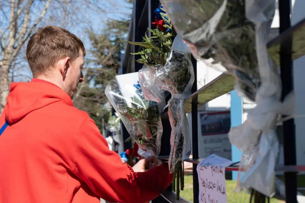 Un hombre se aproxima a la entrada del Nacional para dejar flores en homenaje al futbolista. Foto: EFE.