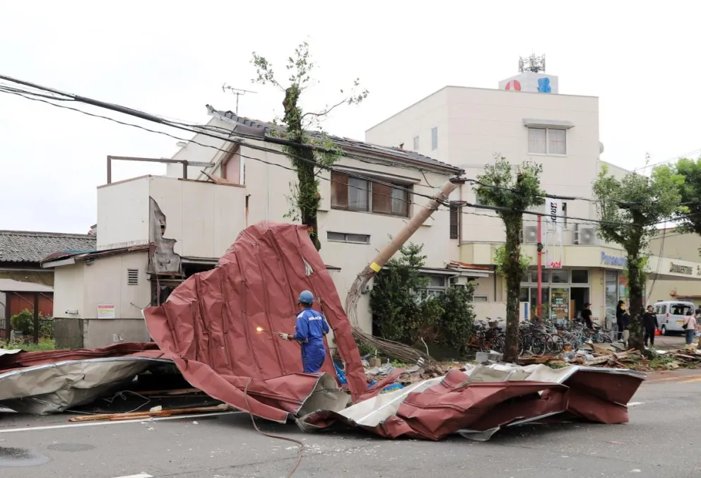 Un trabajador entre escombros arrastrados por los fuertes vientos. Fotos: EFE
