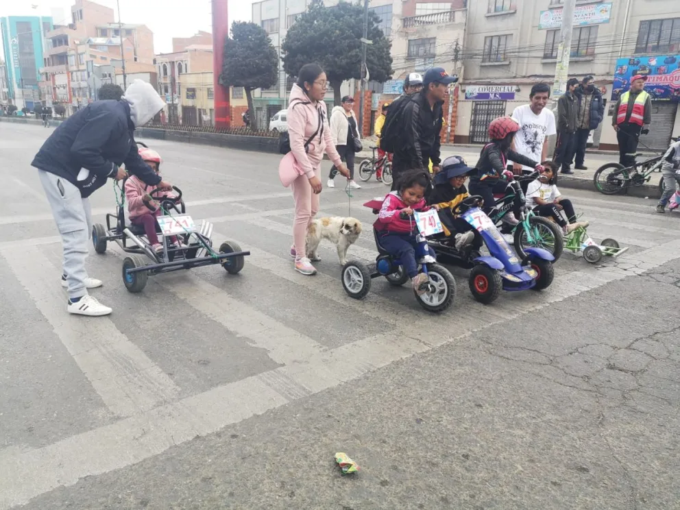Un grupo de personas participa de una carrera de cochecitos sin motor, en el Día del Peatón. Foto: AMUN.
