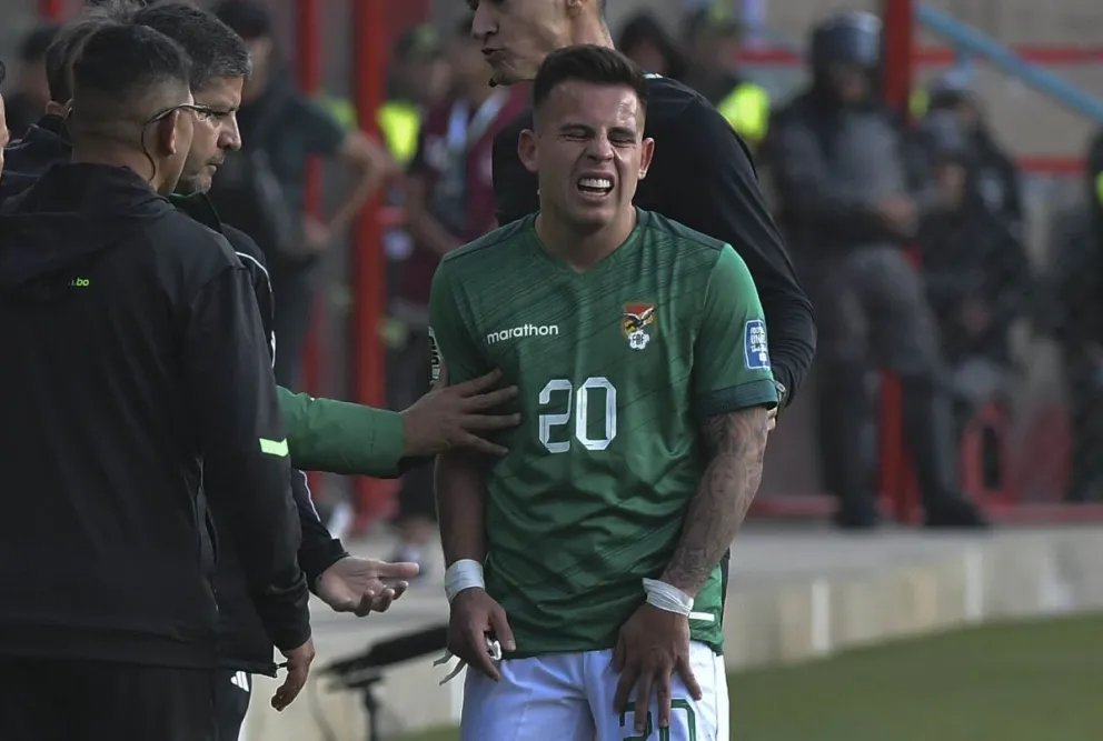 Henry Vaca (der.) y la señal de dolor en su pierna izquierda en el partido de la selección frente a Venezuela en El Alto. Foto: APG