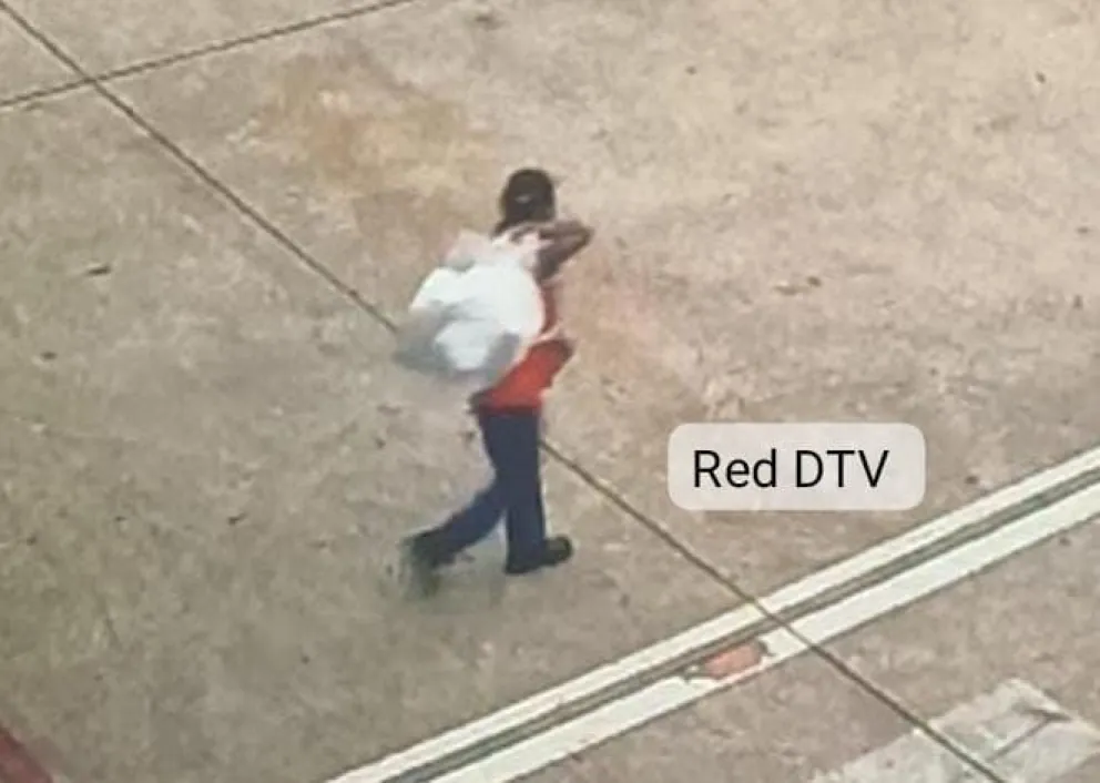 Una de las funcionarias de la empresa de limpieza, llevando la bolsa hasta el interior del avión. Foto: DTV