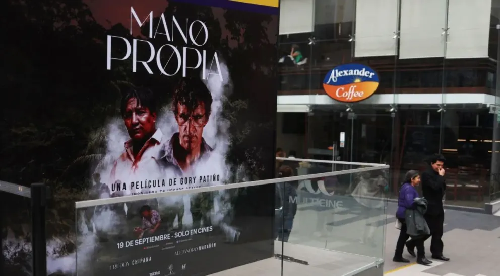 Una pareja pasa frente a un cartel promocional de la película "Mano Propia", en La Paz. Foto: EFE 