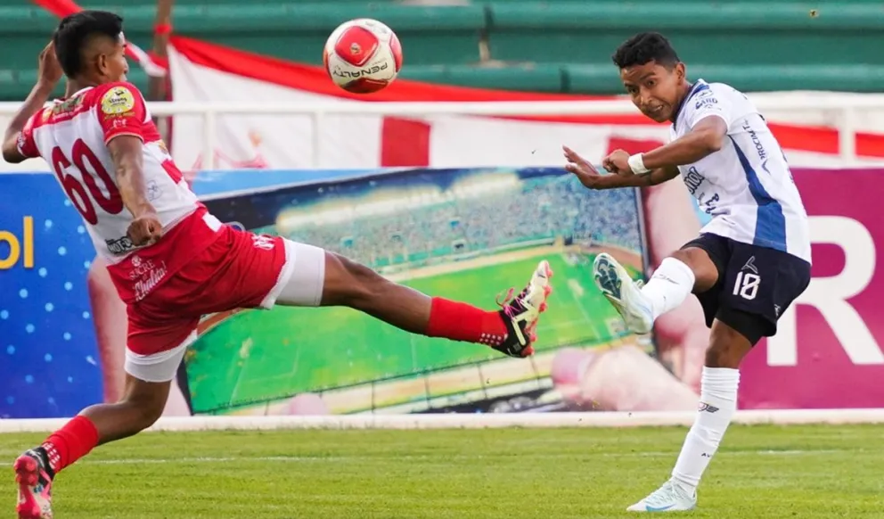 Leonel López (der.), jugador de Wilstermann, ensaya un remate ante la oposición de Yosser Suárez, de Independiente. Foto: APG